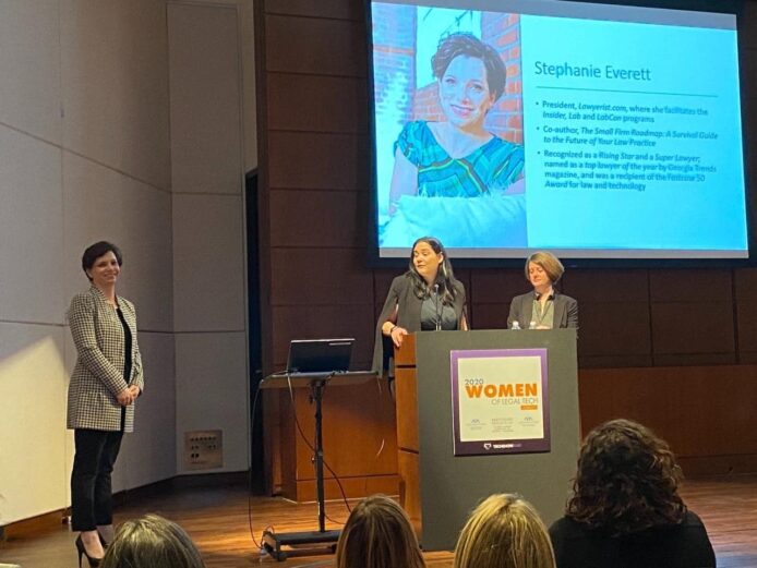 Everett standing on stage with two women presenters who are honoring her with the 2020 Women of Legal Technology Award 