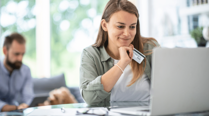 Woman staring at computer with payment card