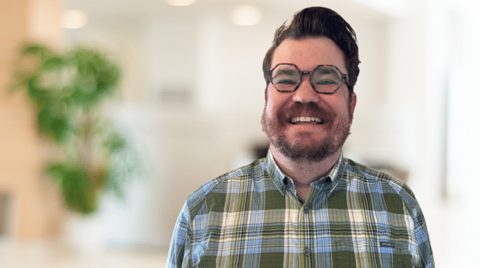 Picture of Dan Wade smiling, with glasses, wearing a green plaid shirt